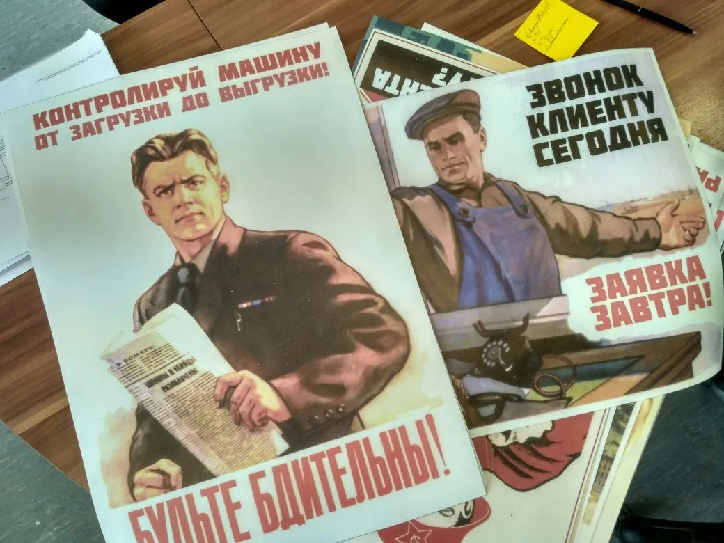 Постеры на столе: «Звонок клиенту сегодня — заявка завтра» и «Контролируй машину»